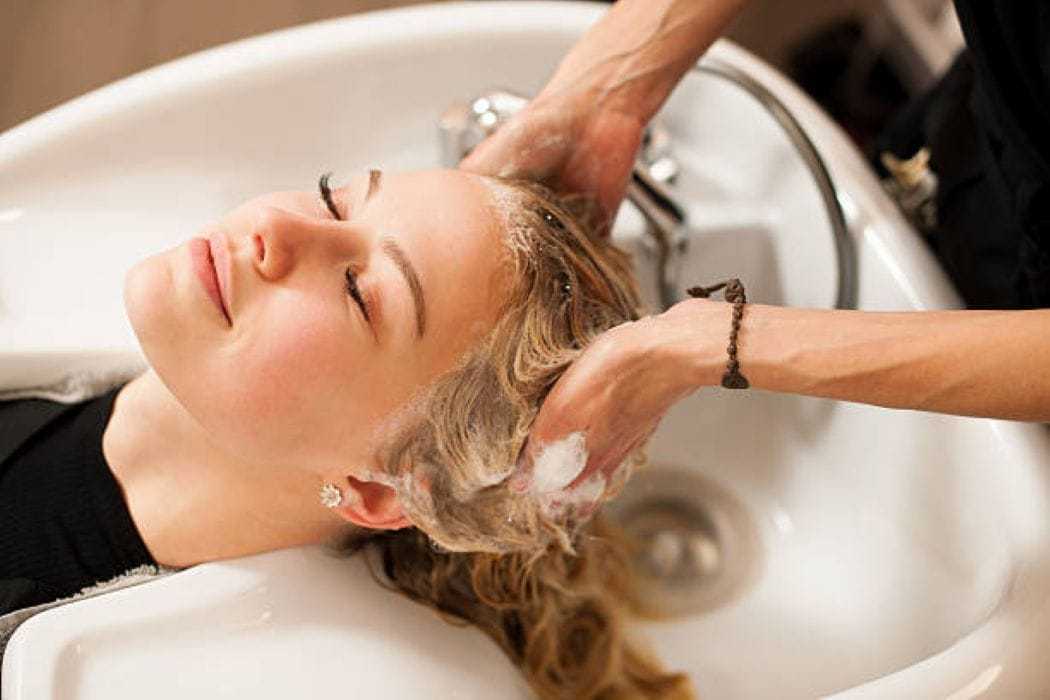 A woman enjoying a shampoo treatment at a salon.